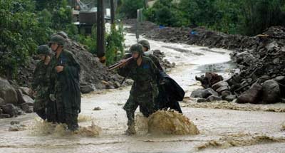 圖為救援官兵冒雨參與抗洪搶險(xiǎn)。